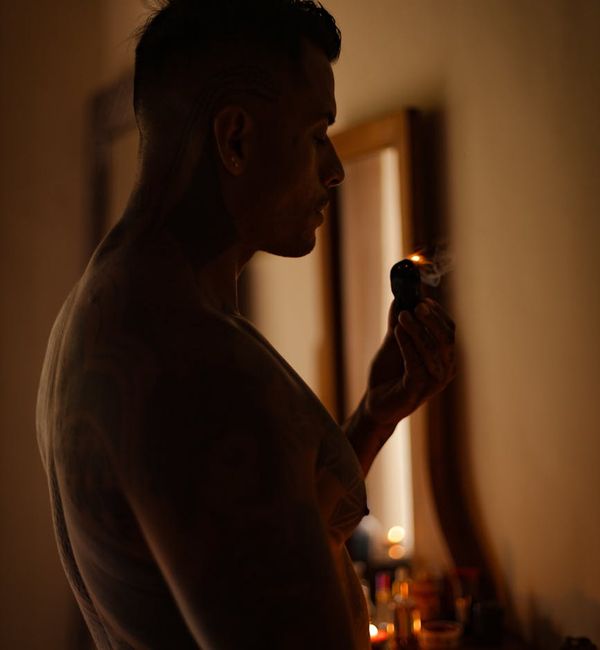 Person meditating peacefully in a dimly lit room with a warm glow.